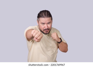 A man shows off his boxing moves. Making straight jabs. Lighthearted scene of a man pretending to throw a punch. - Shutterstock ID 2201769967