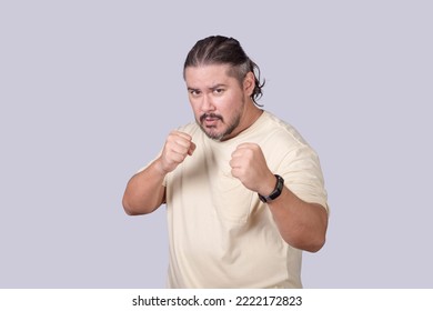 A man shows off his boxing moves with a defensive stance. Lighthearted scene of a man pretending to box. - Shutterstock ID 2222172823