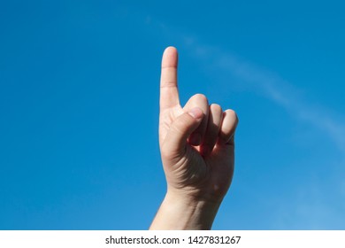 Man shows one finger on a blue sky background
