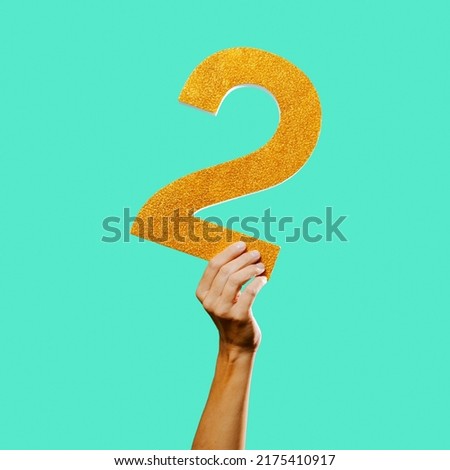a man shows a three-dimensional number 2 against a greenish blue background