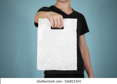 Man shows white blank plastic bag mock up isolated. Empty white polyethylene package mockup. Consumer pack ready for logo design or identity presentation. Commercial product food packet handle