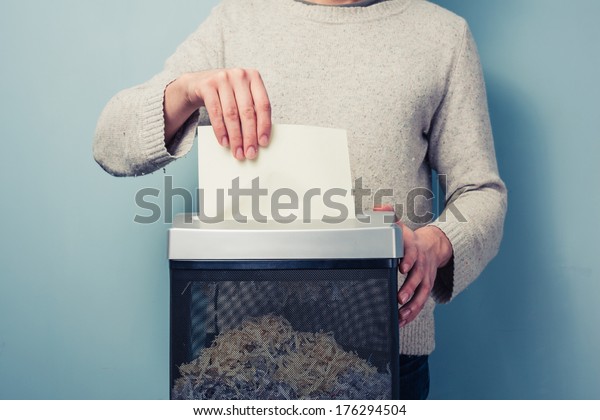 Man is shredding a piece of\
paper