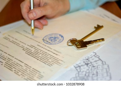man signing document with pen on the buying and selling of the apartment - Shutterstock ID 1032878908