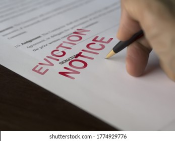 Man signing signing an eviction notice to a defaulting renter in due to missed rent in recession - Shutterstock ID 1774929776