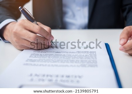 man signing on contract documents after reading, man holding pen and approve on business report. Contract agreement, law and deal concepts