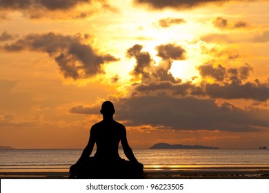 Man Silhouette Doing Yoga Exercise At Sunset Beach