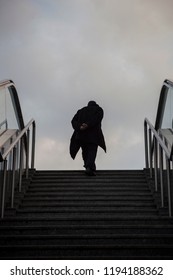 Man Silhouette Emerging From Stairs. Sky In The Background.