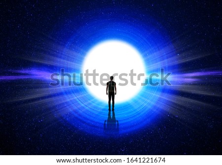Man silhouette at the end of the tunnel with the universe and blinding light in the background