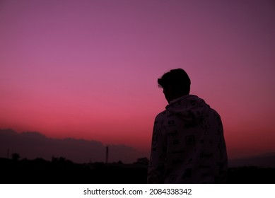 A Man Sillhouette Enjoying A Beautiful Sunset In The City.