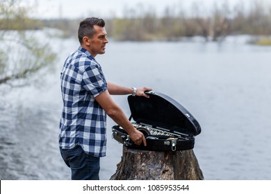 A Man With The Silver Vintage Sax Outdoors Aggetng The Sax Out Of The Case