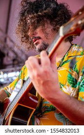 Man Singing And Playing Acustic Guitar At A Concert