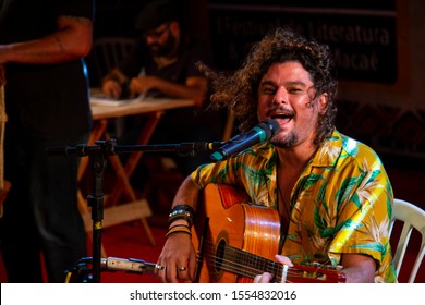 Man Singing And Playing Acustic Guitar At A Concert