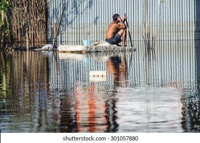 Man sit safety on a flooded section of road in Bangkok
