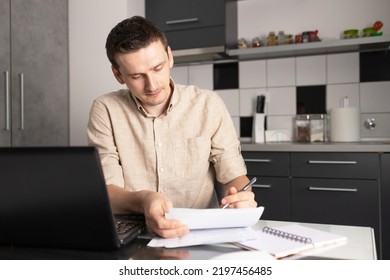 Man Siting By Laptop And Making Notes. Handsome Man Taking Notes At Home Office, Portrait.