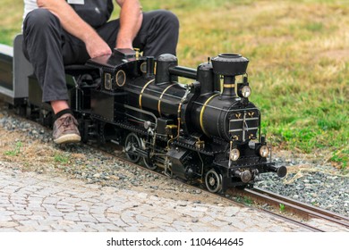 Man Siting On Old Mini Train. Train Model. 