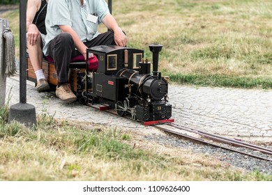 Man Siting On Old Mini Train. Train Model. 