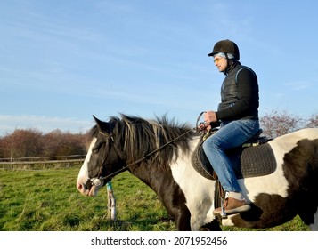 A Man Sits Astride A Piebald Horse