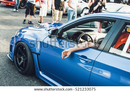 Man sits in blue BMW on the street