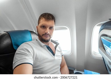 A Man Sits In Front Of An Airplane Window And Is Nervous, Afraid To Fly, The Cabin Of A Passenger Aircraft. Aerophobia, Fobilya, International Flights