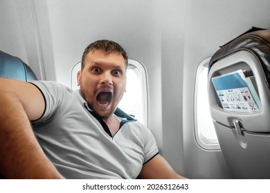 A Man Sits In Front Of An Airplane Window And Is Nervous, Afraid To Fly, The Cabin Of A Passenger Aircraft. Aerophobia, Fobilya, International Flights