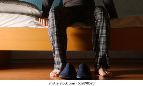 Man sits on a bed in the night at home - Powered by Shutterstock