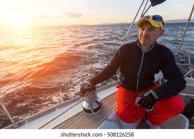 A Man Sits On His Sailing Yacht During Sunset. Luxery Boats. 