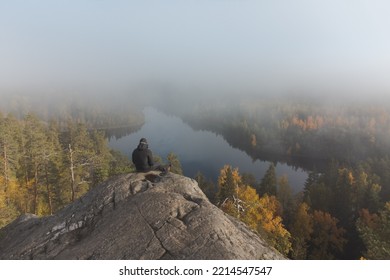 A Man Sits On Top Of A Granite Mountain. Atmospheric Hazy View