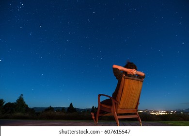 Man Sitting In Armchair Under The Stars
