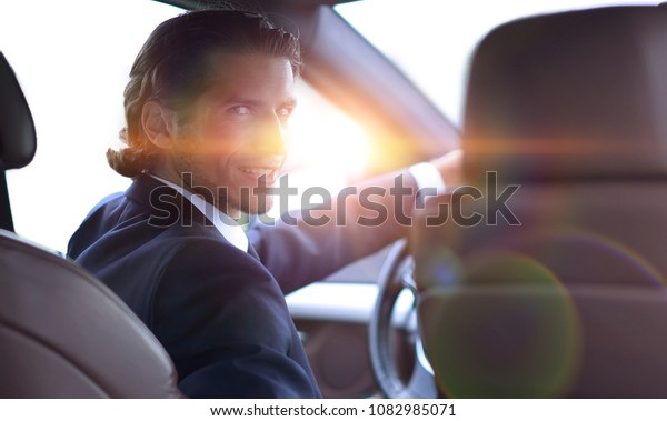 man sitting behind the\
wheel of a car