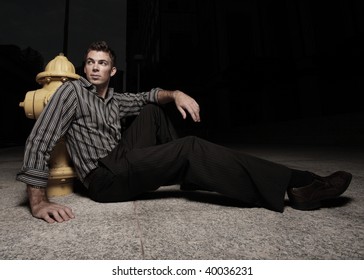 Man sitting by a fire hydrant