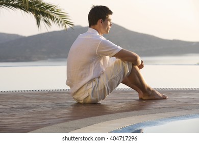 A man sitting by a pool