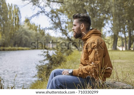 Man sitting by the river in fall