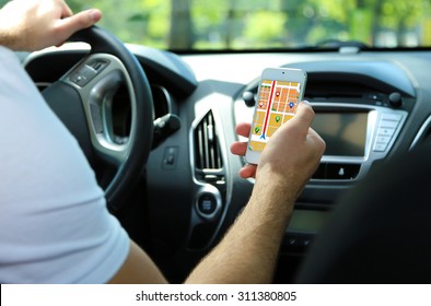 Man Sitting In The Car And Holding Smart Phone With Map Gps Navigation Application