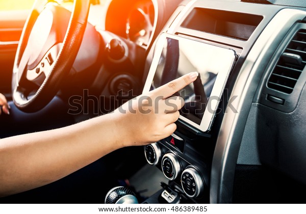 Man sitting in car and holding tablet with map\
gps navigation, toned at\
sunset.