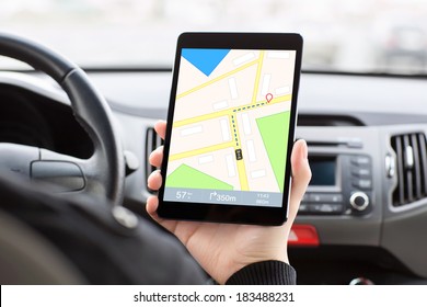 Man Sitting In A Car, Holding A Touch Tablet With A GPS  Navigator On The Screen.