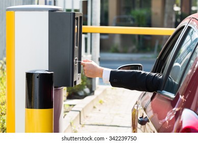 Man Sitting In Car Inserting Ticket For Parking Area