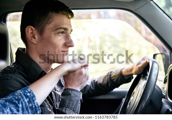 a man sitting in a car kissing a girl\'s hand,\
romantic feelings and love