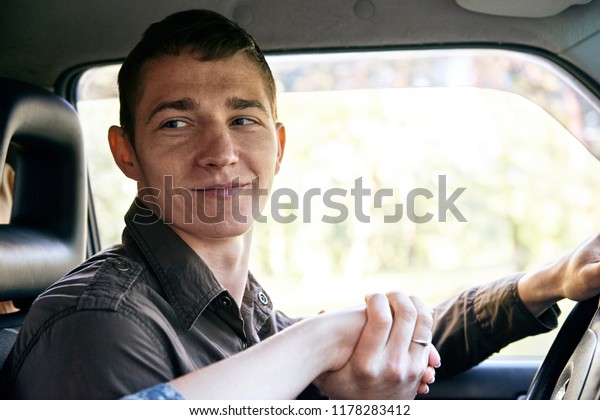 a man sitting in a car kissing a girl\'s hand,\
romantic feelings and love