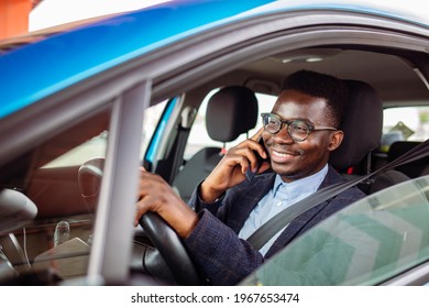 Man Sitting In Car With Mobile Phone In Hand Texting While Driving. Distracted Shocked Guy Checking His Smart Phone Not Paying Attention At Road Annoyed By Bad Text Message Email Outdoors Background