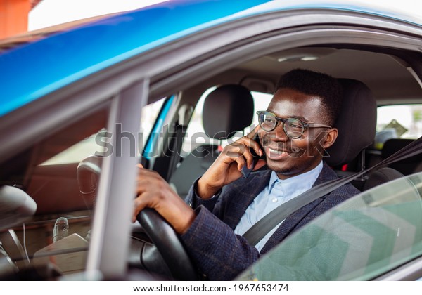 Man sitting in car with mobile phone in hand\
texting while driving. Distracted shocked guy checking his smart\
phone not paying attention at road annoyed by bad text message\
email outdoors background