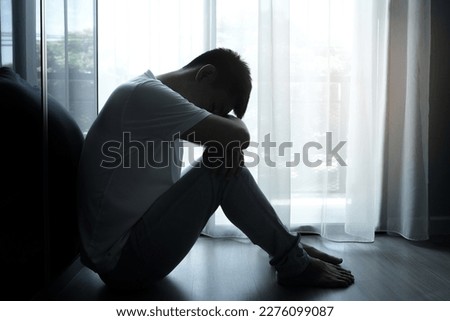 the man sitting in the corner of the room has emotional and mental problems He has depression and stress from society and work. medical concept.