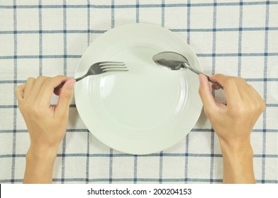  Man Sitting At The Dinner Table With Fork  And Spoon And Empty Plate