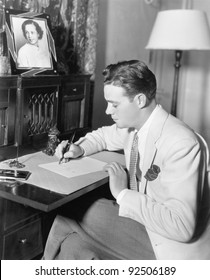 Man Sitting At His Desk Writing A Letter With A Fountain Pen