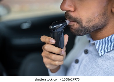 Man Sitting Inside Car Taking Alcohol Test