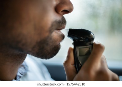 Man Sitting Inside Car Taking Alcohol Test