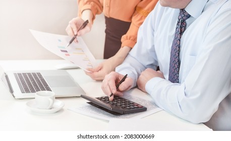 A man is sitting at a laptop. The manager explains the errors in the document to the employee. High quality photo
