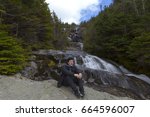 Man sitting and looking out from elevation on Mount Washinton via Ammonoosuc ravine trail in Coors County,  New Hampshire.