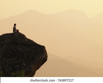 A Man Sitting And Meditating On A Top Of A Mountain. Greece Meteora         