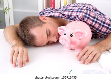 Man Sitting In Office Sleeping With Pink Pig Money Box