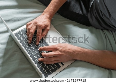 Man are sitting on a bed and working on laptop. Concept of online work or study